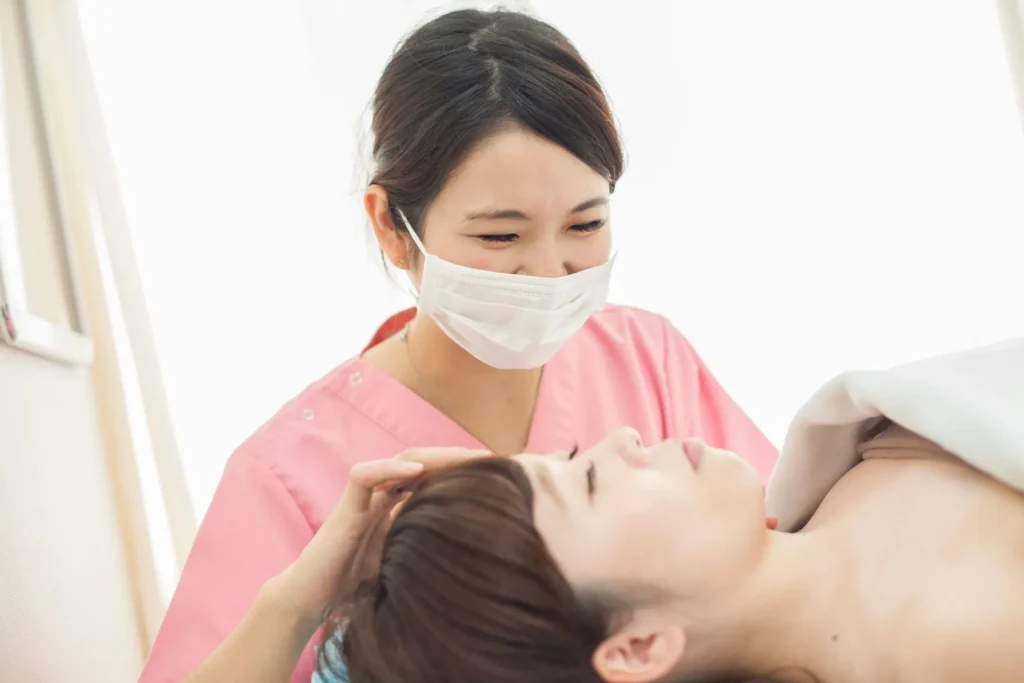 顔脱毛の施術を受ける女性と担当する看護師