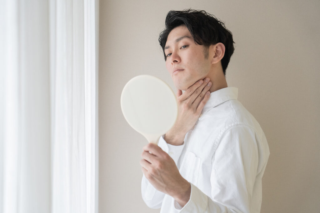 手鏡で口元を確認する男性